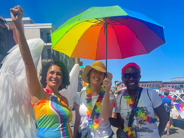 Staff members with rainbow-coloured umbrella in Victoria's 2024 Pride parade 