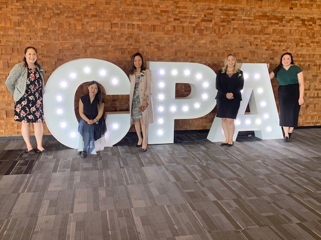 5 OAGBC staff pose in front of 5-foot tall C-P-A letters