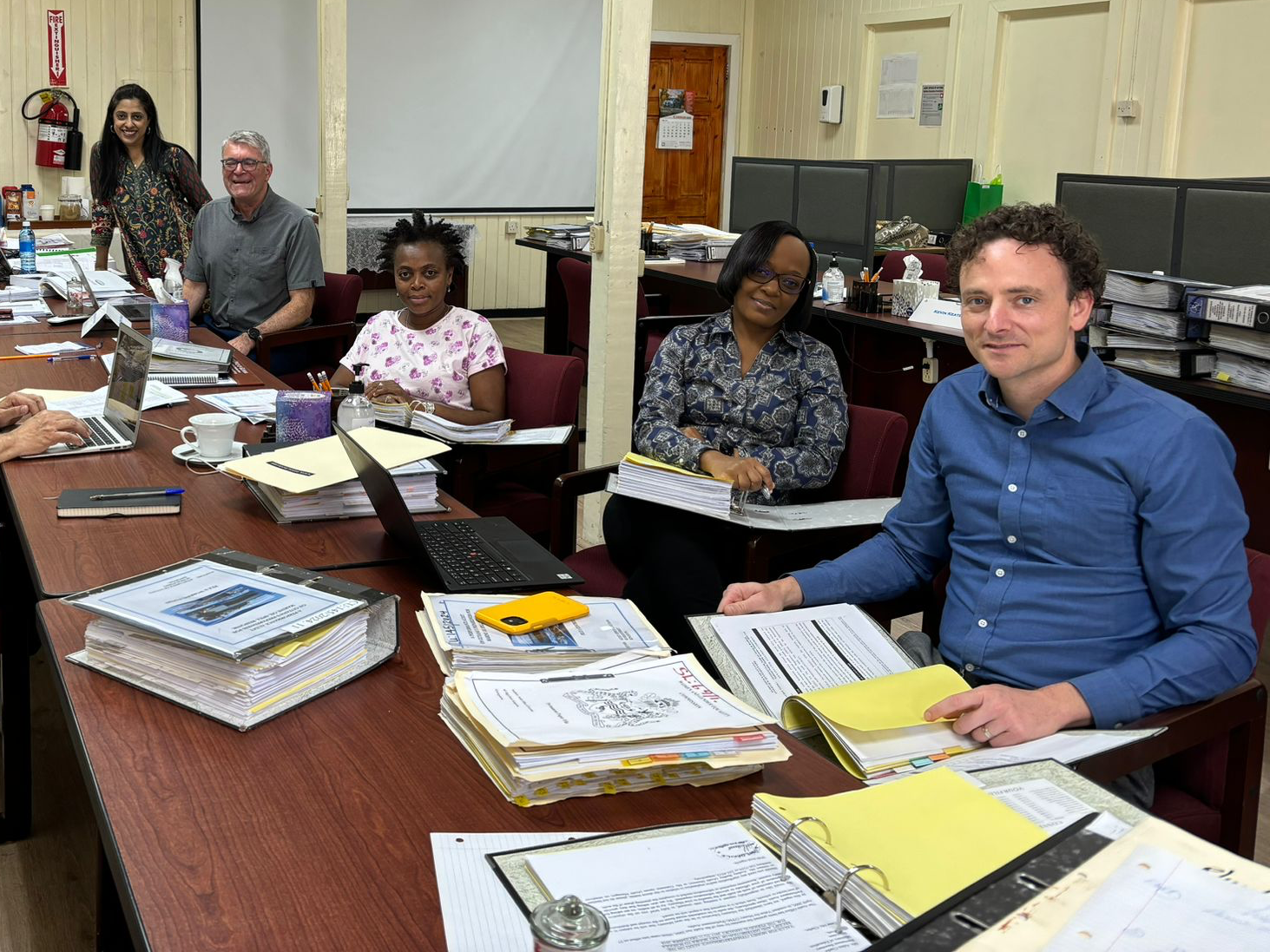 OAGBC staff work at a table with audit staff in Guyana