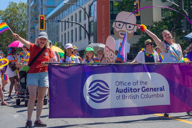 Staff members hold office banner in Victoria's 2024 Pride parade