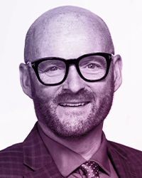 Portrait of a middle aged man, bald, short stubble bear, thick black glasses, with a sport coat and tie on. Name: Michael Pickup.