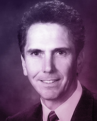 Portrait of an middle aged man, short brown hair, in a suit and tie. Name: Wayne Strelioff.